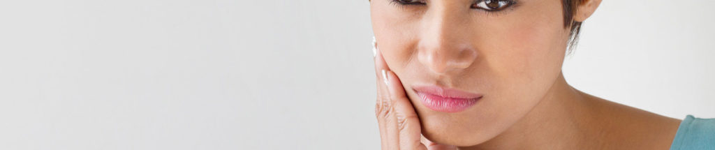 Woman holding her face in pain